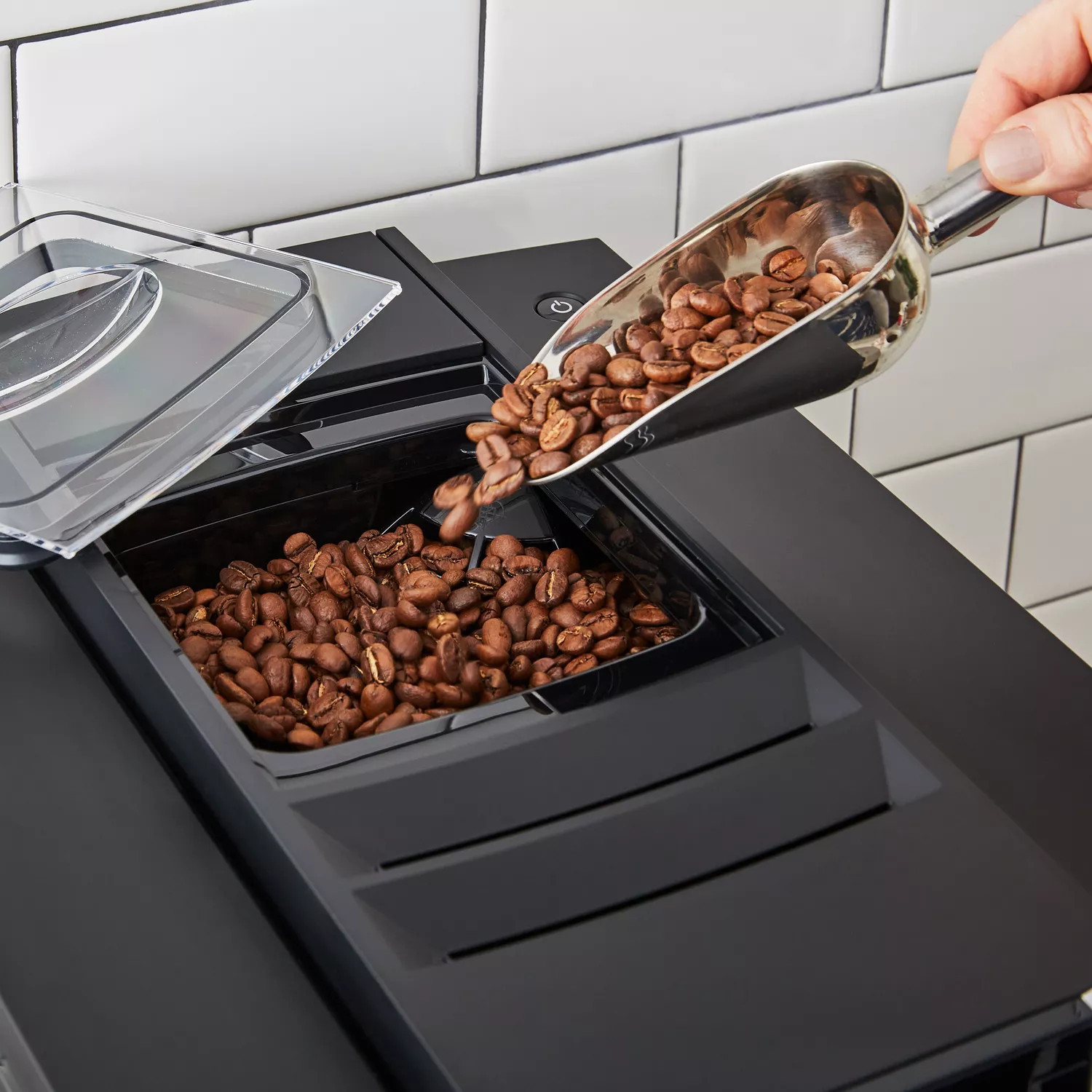 Café en grano cayendo en la tolva de una cafetera superautomática de oficina